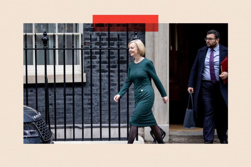 Liz Truss walking in Downing Street. She is wearing a green dress.