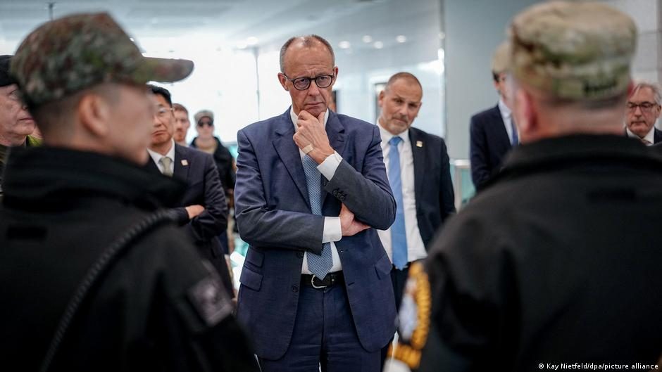 Friedrich Merz speaking in Seoul in front of a picture of himself