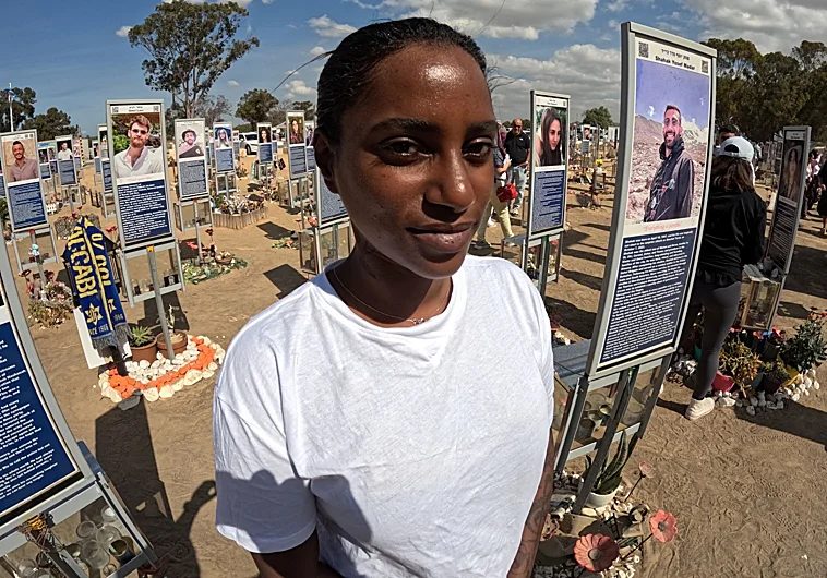 Imagen principal - Mazal Tazazo, superviviente del Nova en el memorial por las víctimas en Re'im, junto a Gaza. En un momento de la conversación, acaricia las fotos de sus compañeros y amigos que muri