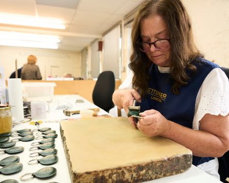 A worker at the Ettinger factory carefully stitches a leather keyring fob