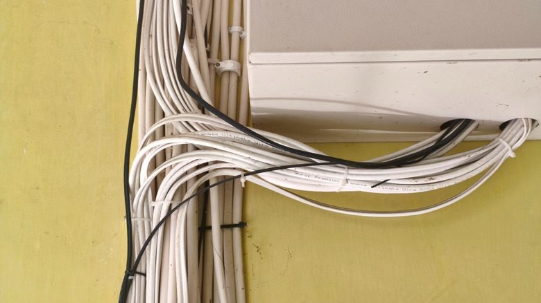 Electrical and Ethernet cables bound by zip ties and running into a junction box.