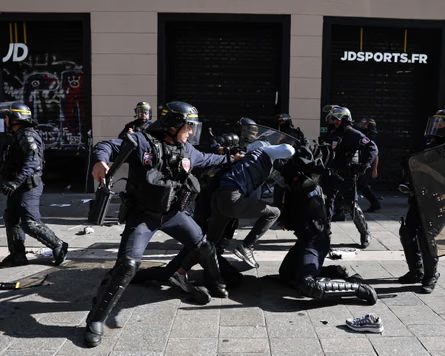 French riot police detain a protester on the ground during a Marseille demonstration