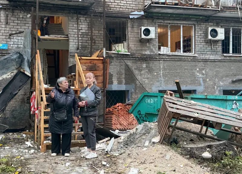 Habitantes locales en el lugar de un ataque ruso contra una zona residencial en Zaporiyia, Ucrania, el 17 de octubre de 2026.