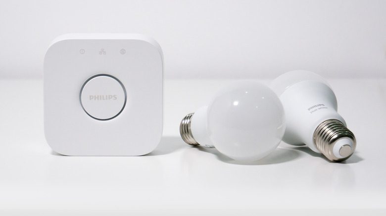 A Philips Hue Bridge with a pair of Hue White smart bulbs.