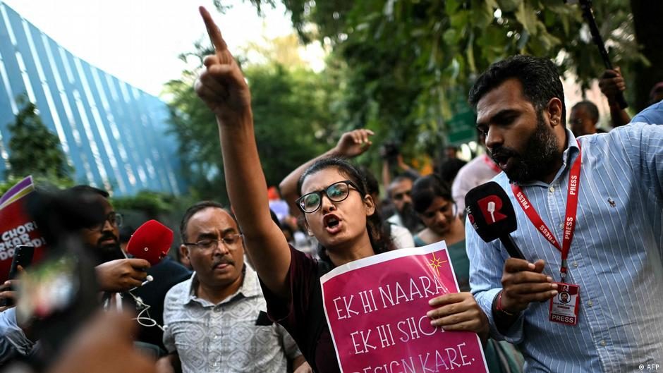 Neha Bora shout slogans from a police bus after being detained