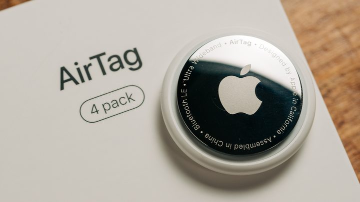 Un Apple AirTag sobre una superfície amb una pila CR2032 al costat.